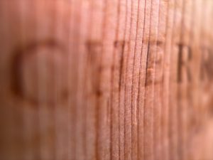 Closeup of a piece of wood with the word "Cherry" burned into it.