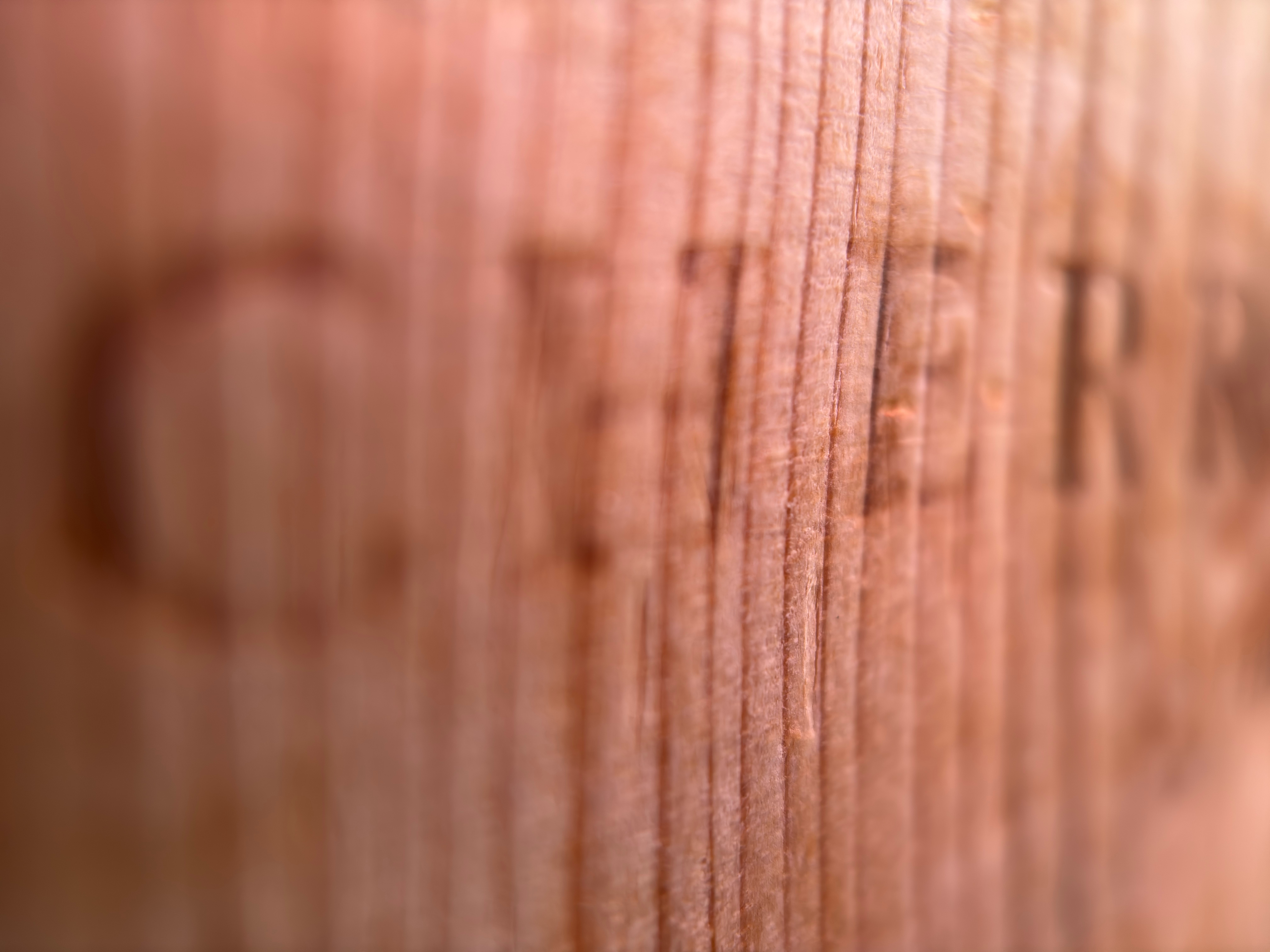 Closeup of a piece of wood with the word "Cherry" burned into it.
