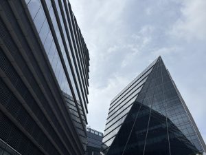 A low-angle view of two modern skyscrapers featuring sleek glass facades