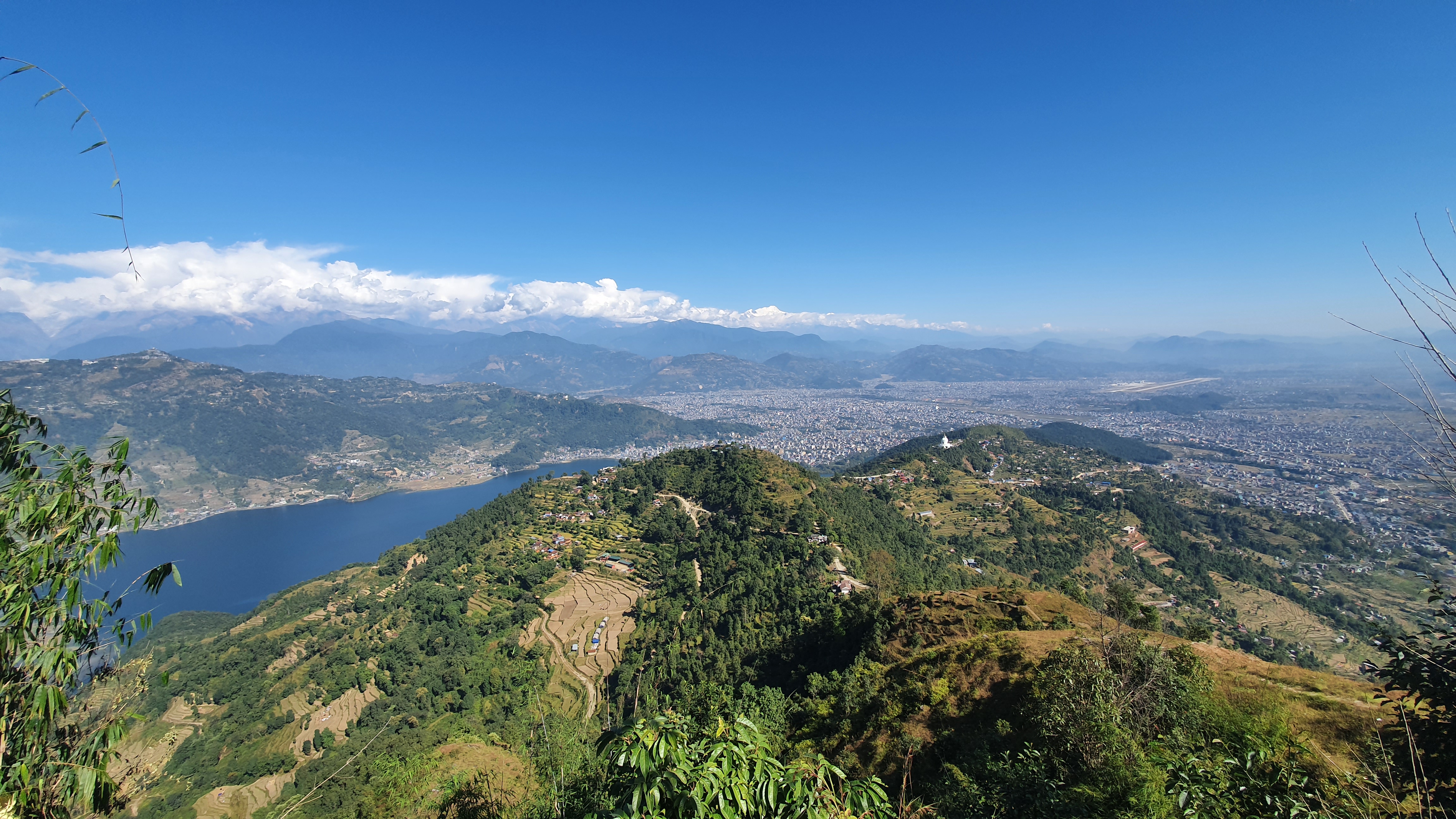 Scenic view of a lake and mountains from a hilltop in Pokhara, Nepal, showcasing natural beauty and tranquility.