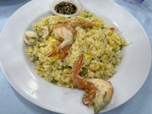 Fried rice with prawns and vegetables on a white plate.

