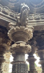 Close-up view of the beautifully carved stone pillars and ornate beam supports at Shree Kopeshwar Mandir, showcasing detailed sculptures, floral motifs, and robust architectural craftsmanship.