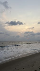 A serene beach at sunset, with soft waves gently lapping at the sandy shore.
