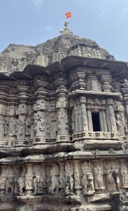 A close-up view of a beautifully intricately carved temple structure featuring various stone sculptures of deities and mythical creatures