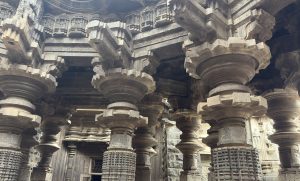 Massive intricately carved stone pillars at Shree Kopeshwar Mandir, Kolhapur supporting the temple's ornate ceiling. The detailed patterns and sculptural artistry reflect the ancient architectural excellence of the temple.