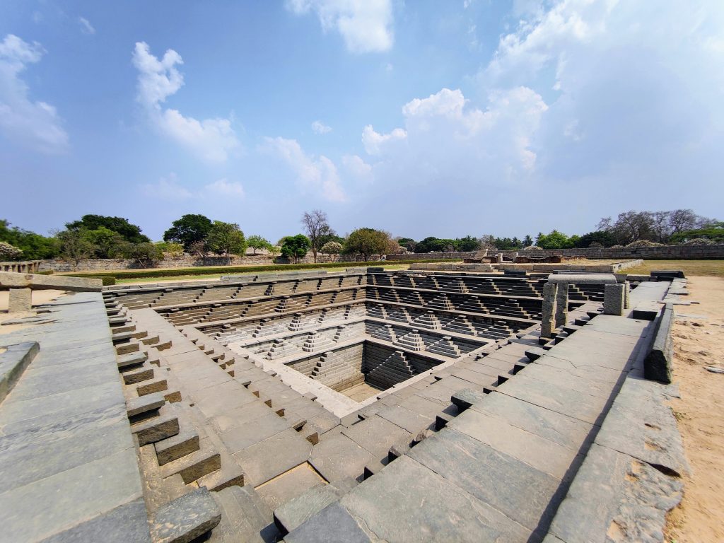 Stepped Tank near Mahanavami Dibba, Hampi, Karnataka — a stunning geometric Pushkarni used for rituals during the Vijayanagara Empire, showcasing exquisite ancient Indian architecture.