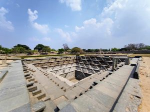 Stepped Tank near Mahanavami Dibba, Hampi, Karnataka — a stunning geometric Pushkarni used for rituals during the Vijayanagara Empire, showcasing exquisite ancient Indian architecture.
