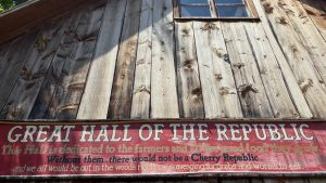 Side of a barn with a rustic sign that says "Great Hall Of The Republic"