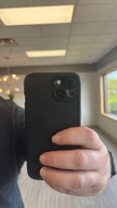 A hand holding a cell phone taking this picture.  The phone case is black.