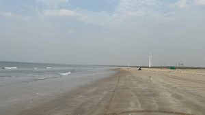 A scenic beach view featuring a wide stretch of sandy shoreline along the water.