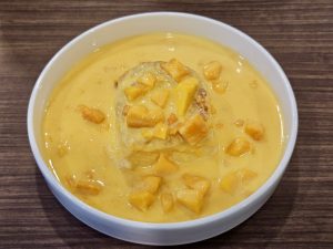 Mango Toast in a white bowl, with a creamy yellow base topped with fresh diced mangoes, captured in Kozhikode, Kerala.