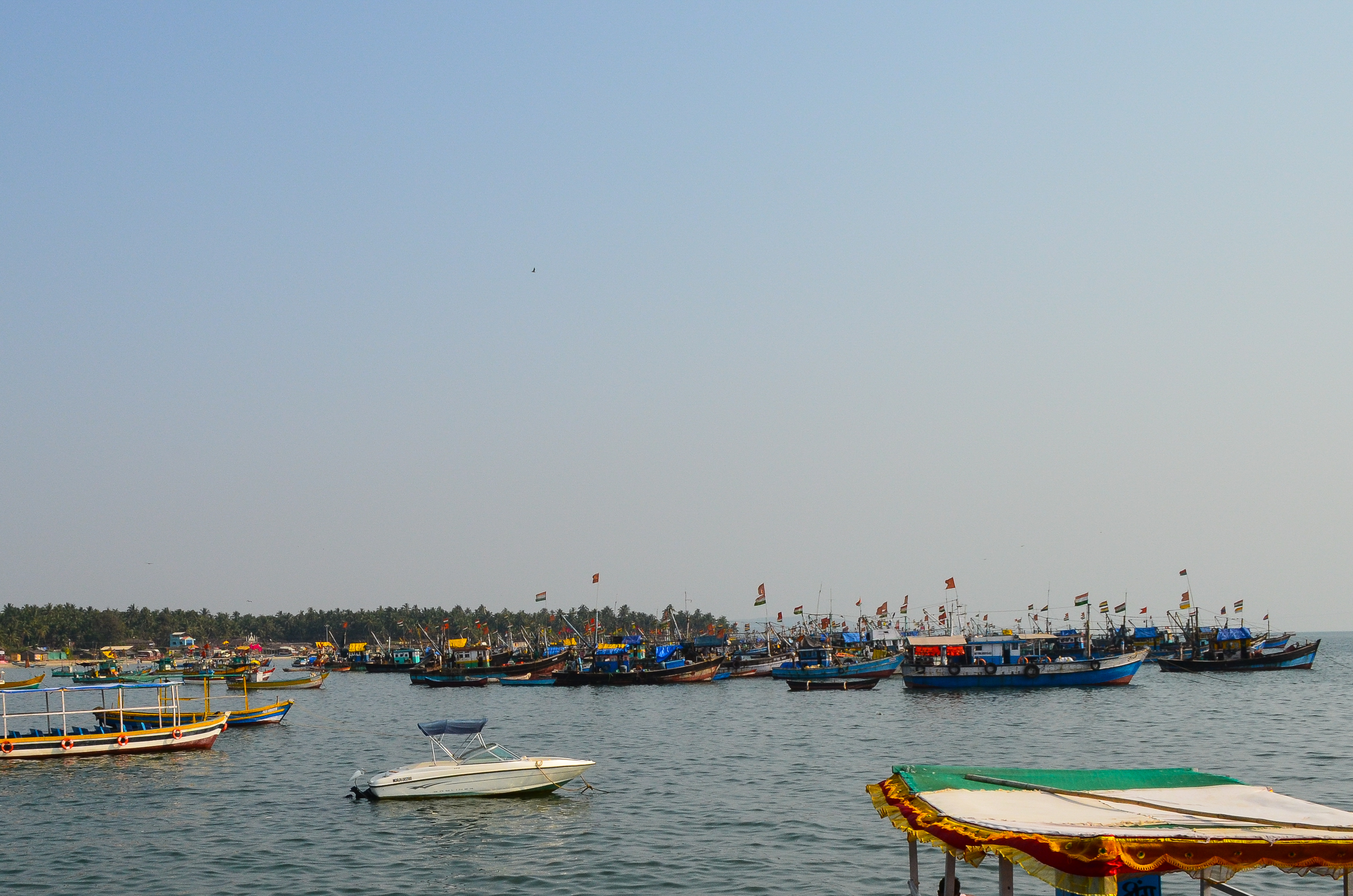 A picturesque scene of a harbor filled with various fishing boats, some adorned with colorful flags.