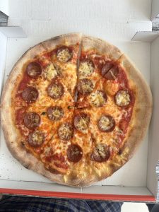 A biggger size of Chicken Pizza and cut in small slices on the paper box. 