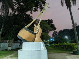 The image shows a sculpture of an Ektara at Lalon Mazar in Bangladesh