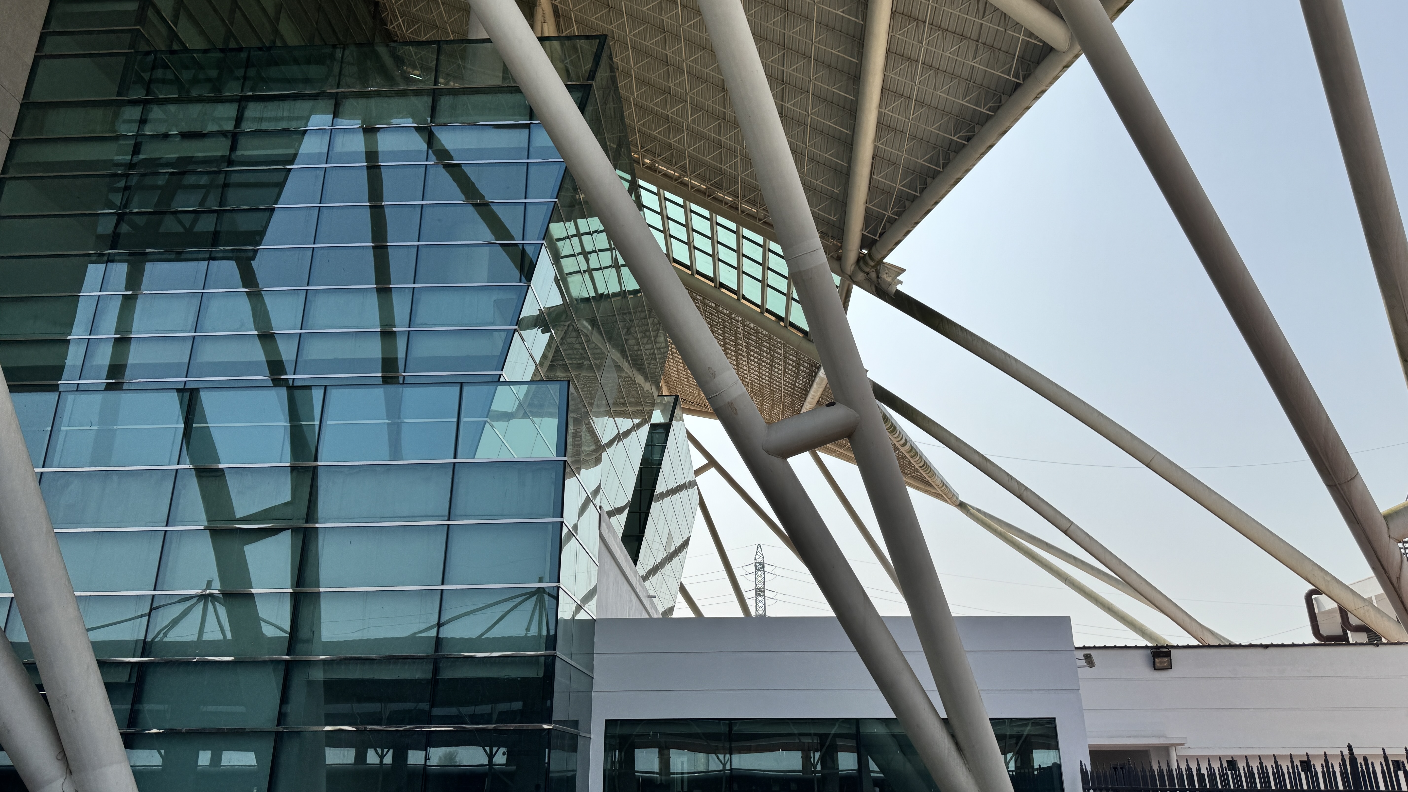 A modern architectural building featuring large glass panels reflecting the surrounding environment.