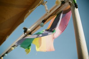 A progress pride flag waving in the wind by the beach in Lesvos, Greece.