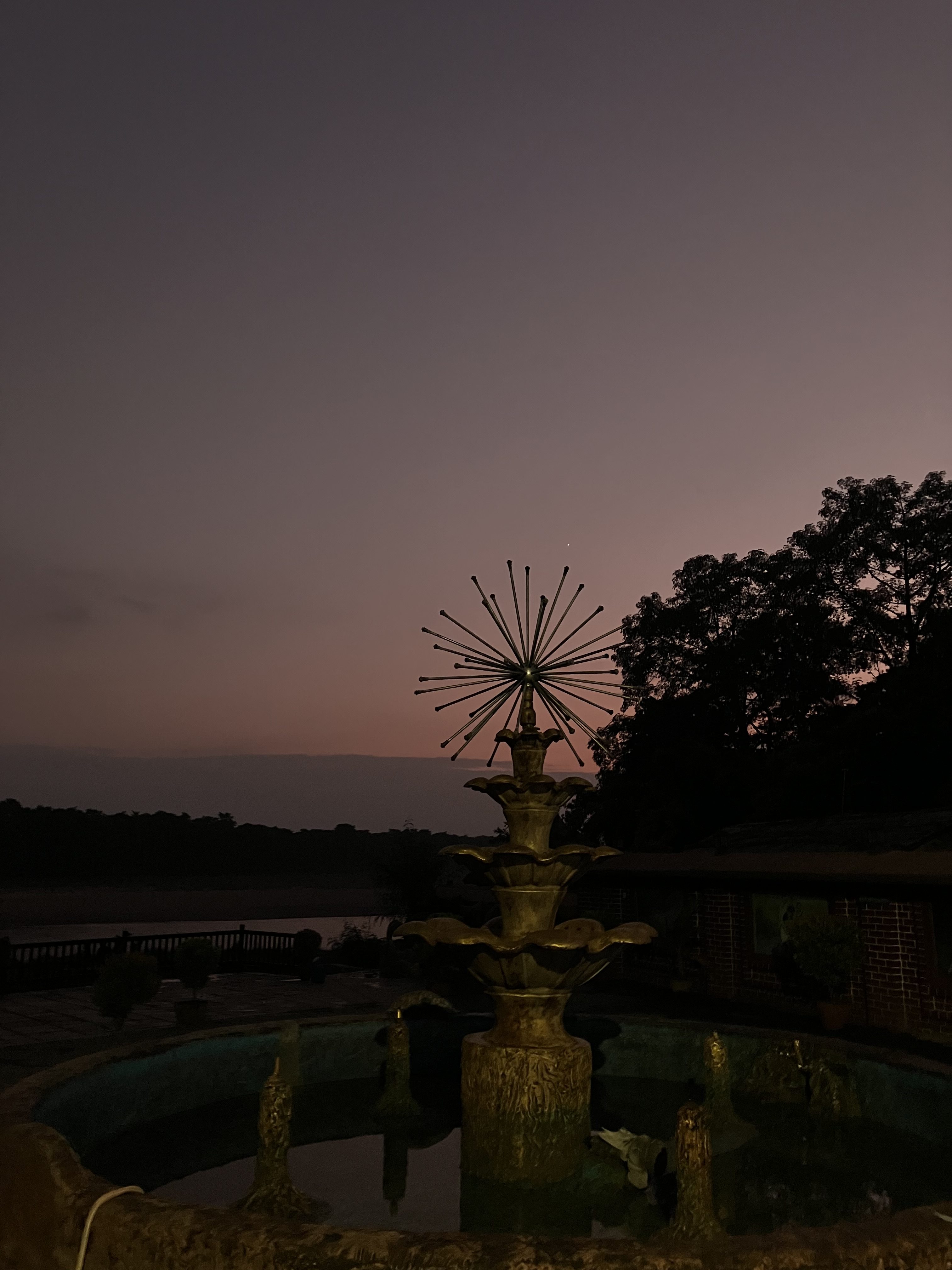 A decorative fountain with a starburst design sits at the center, illuminated by soft lighting.