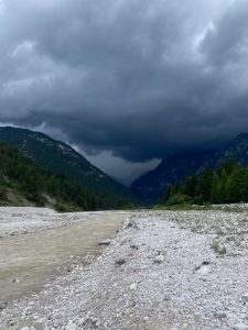 River in Italy, next to the Dolomites, with a dark sky before a storm