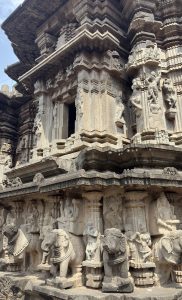 A close-up view of intricately carved stone architecture featuring detailed sculptures of elephants and humanoid figures.