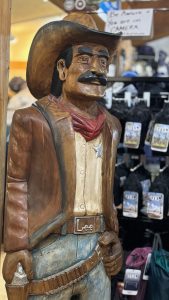 A cowboy sheriff carved out of wood.