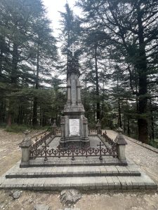 A stone monument surrounded by trees in a forest. 
