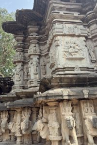 The image depicts an intricately carved stone structure, likely part of a temple or historical monument.