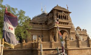 A beautifully carved stone temple shines under a clear blue sky. 