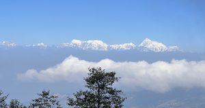 A panoramic view of tall, snow-capped mountains under a clear blue sky. 