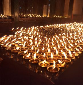 A serene display of butter lamps lit in prayer, symbolizing peace and spiritual devotion. 