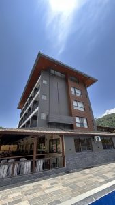 A modern multi-story building featuring a combination of gray and brown materials. 