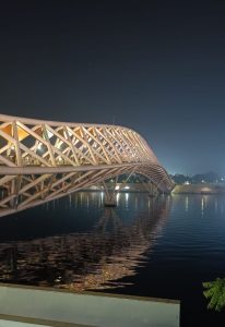 Atal Pedestrian Bridge glowing at night over the Sabarmati River in Ahmedabad.