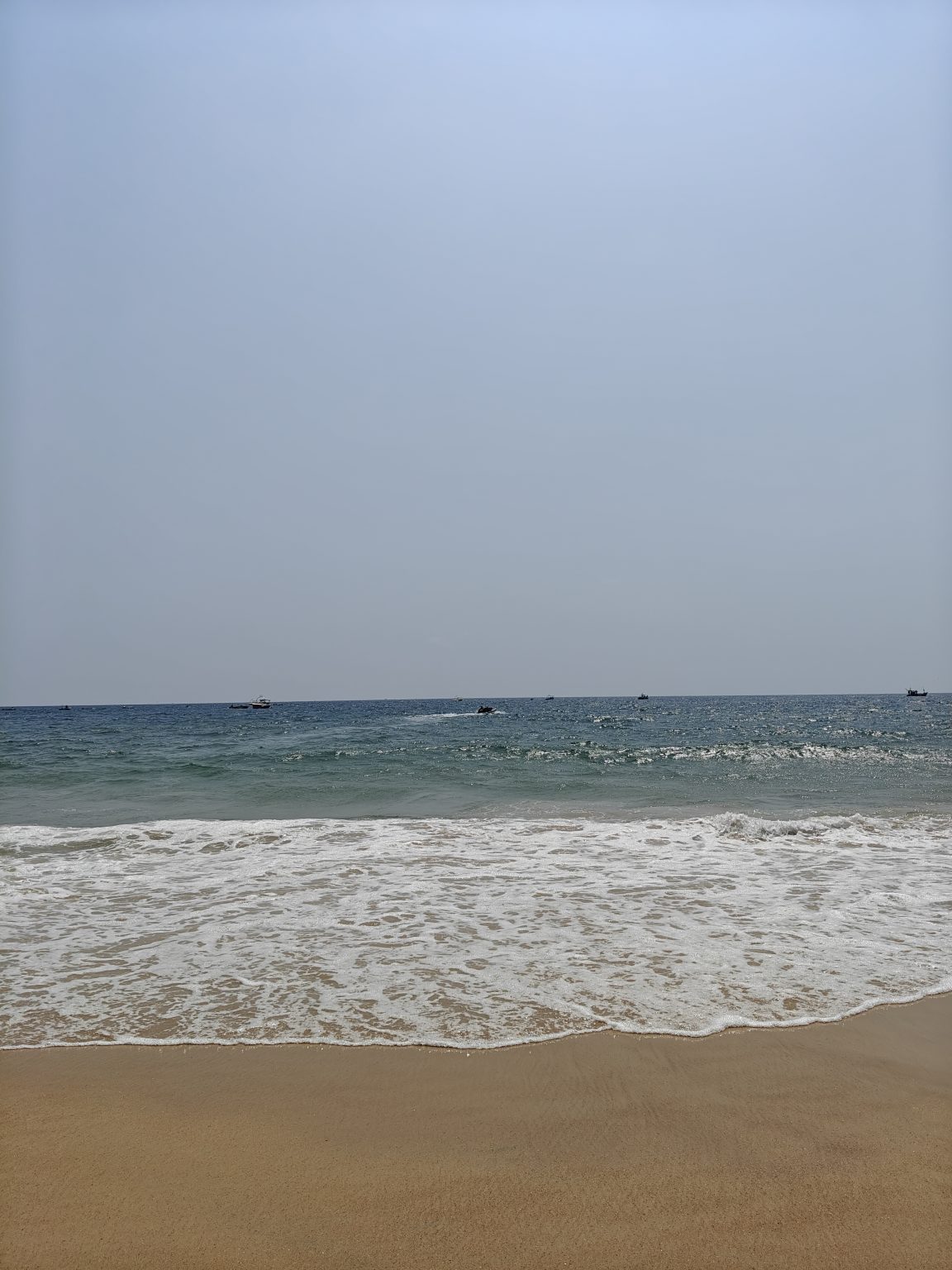 A serene beach scene with gentle waves lapping at the shore.