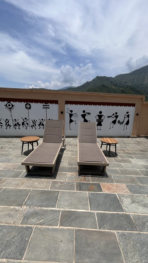 Two modern lounge chairs with gray cushions are positioned on a stone patio.
