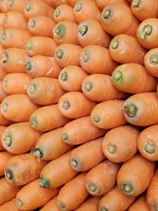 A vibrant pile of fresh orange carrots at a Kozhikode market.