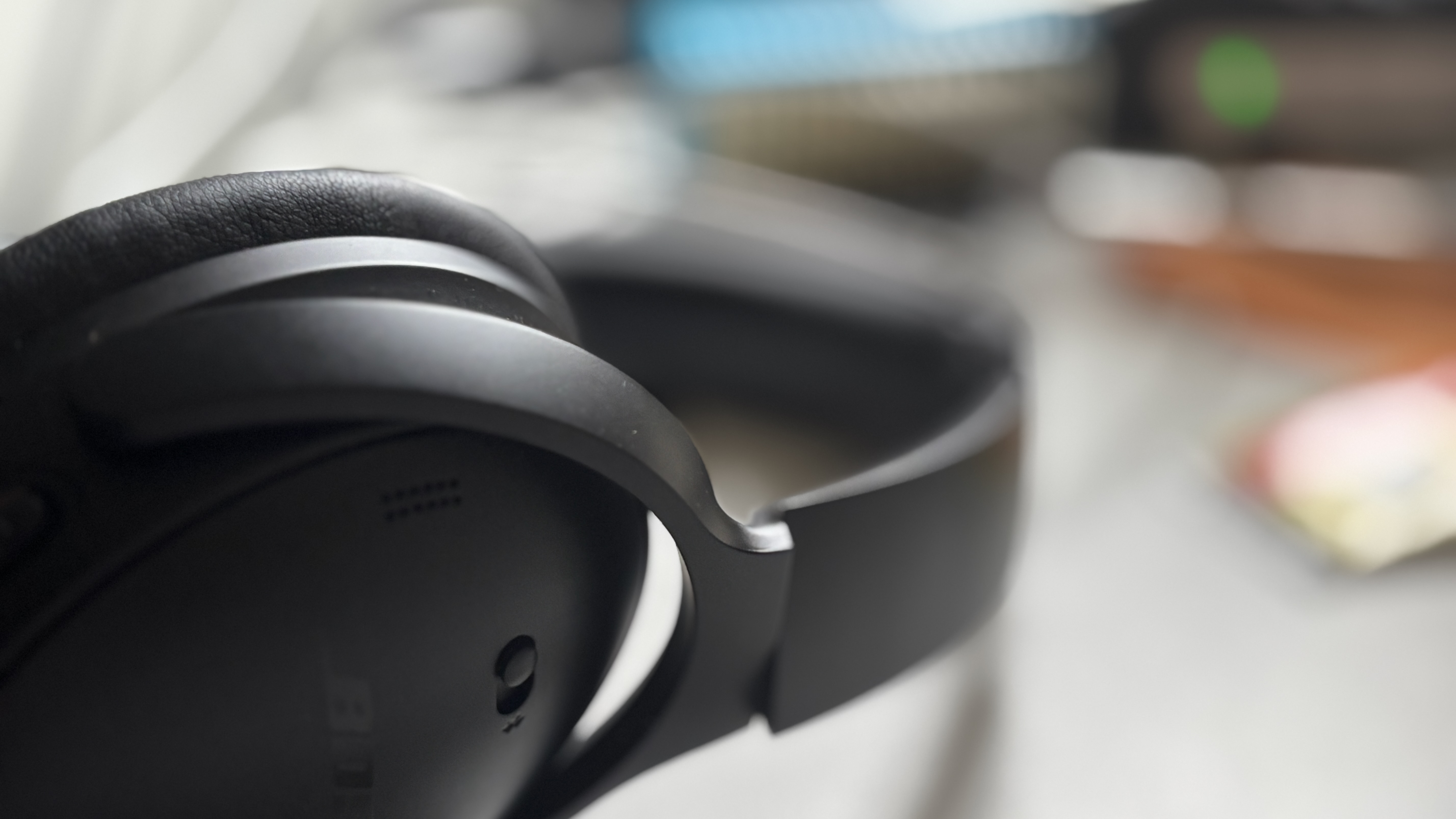 Closeup of headphones on a desk, the background blurry.