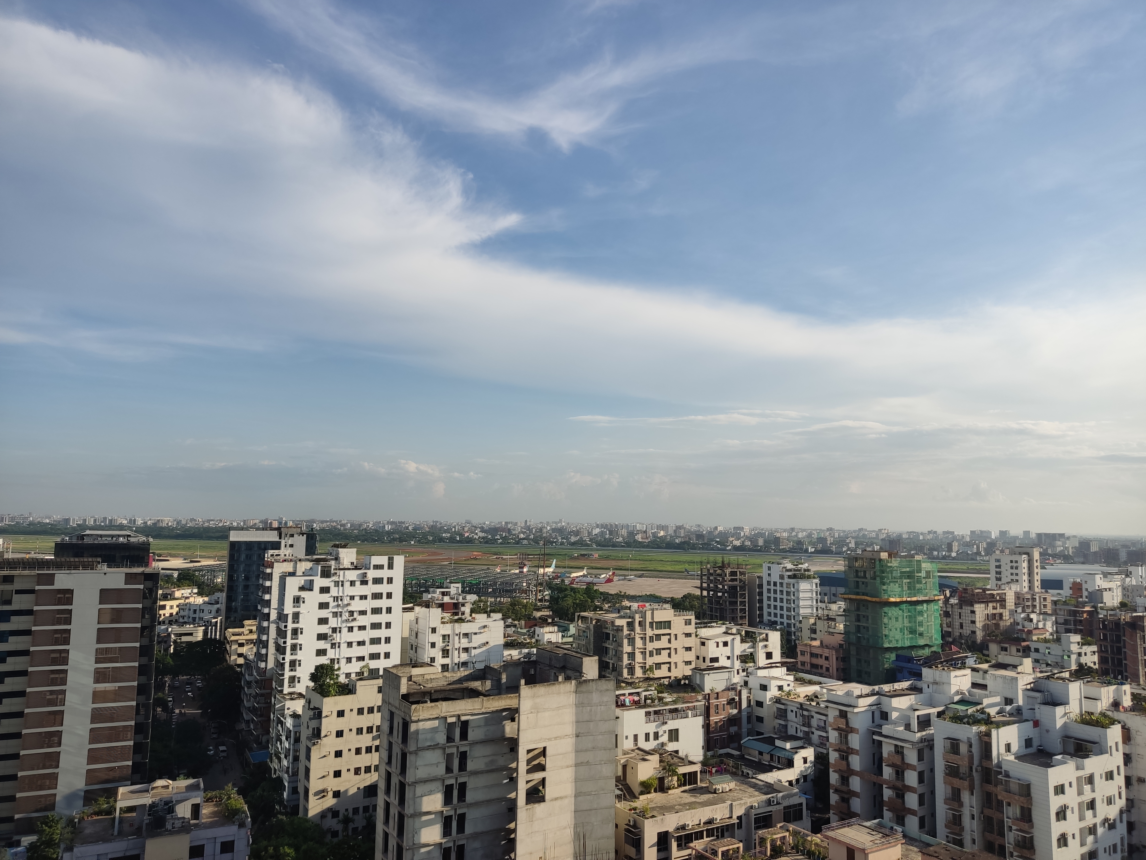 A panoramic view of a cityscape featuring various buildings of different heights and architectural styles.