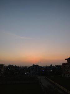 A serene evening skyline featuring a gradient of colors from soft blue at the top to warm orange and peach near the horizon