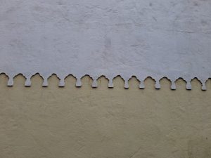 Painted wall. A curvy pattern separates the wall&rsquo;s yellow section from its white section.