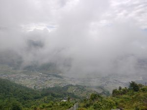 A panoramic view of a mountainous landscape partially obscured by thick clouds