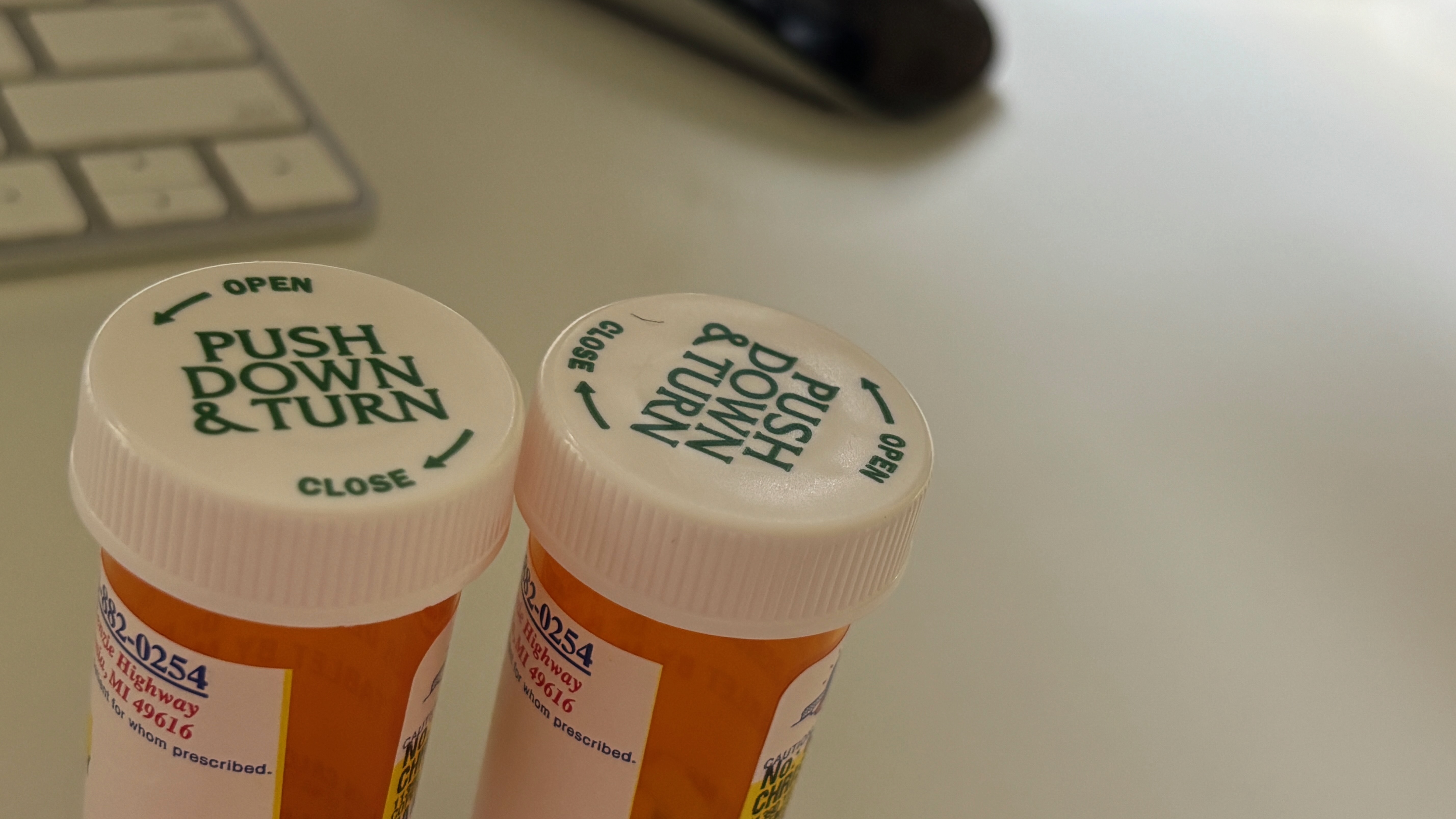 The caps of two medicine bottles on a desk.