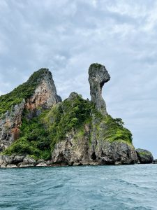 A view of Chicken Island, a large rock formation with a distinctive "chicken head" shape, from the sea in Krabi, Thailand.
