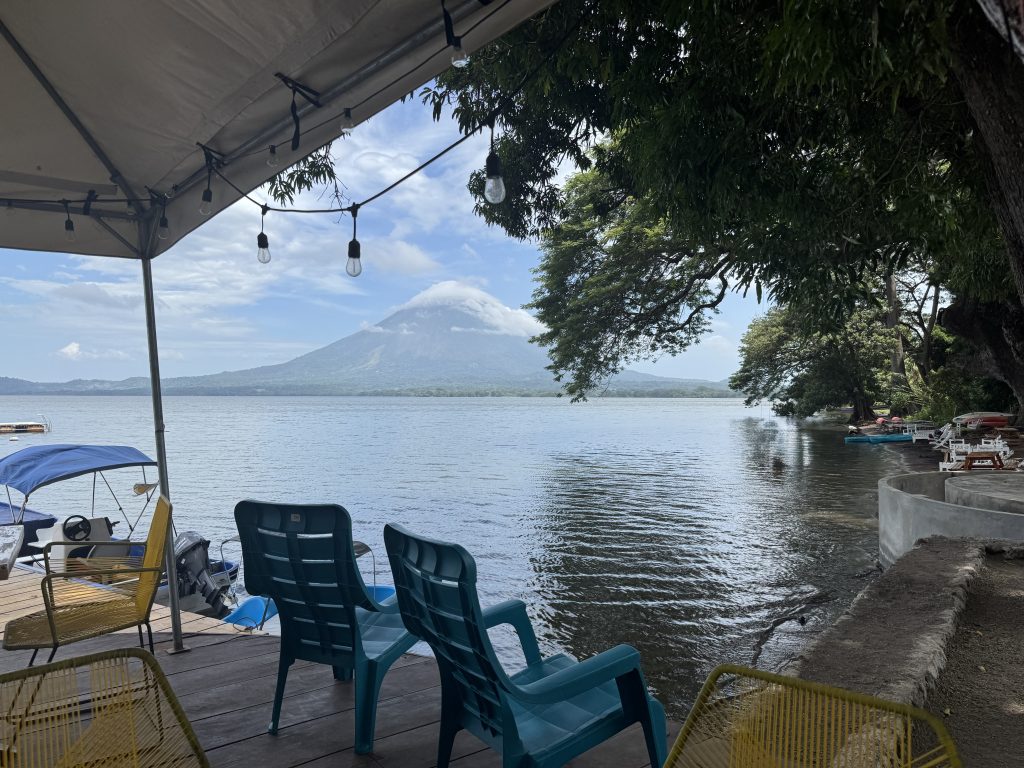 A serene view from a covered deck overlooking a calm lake.