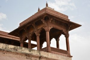 A beautifully carved red sandstone chhatri with delicate arches and lattice panels set against the sky. Captured at Fatehpur Sikri, Uttar Pradesh.