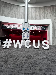 Large event logo in front of a sponsor pole, WordPress US welcome hall.
