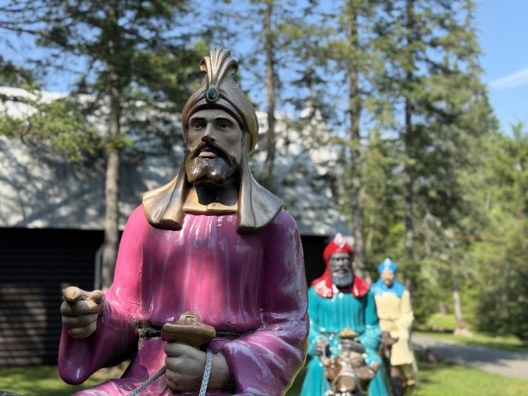 Statues of the three wise men in an outdoor manger scene at Story Land in Bartlett, New Hampshire. Only the first one is focused in the foreground.