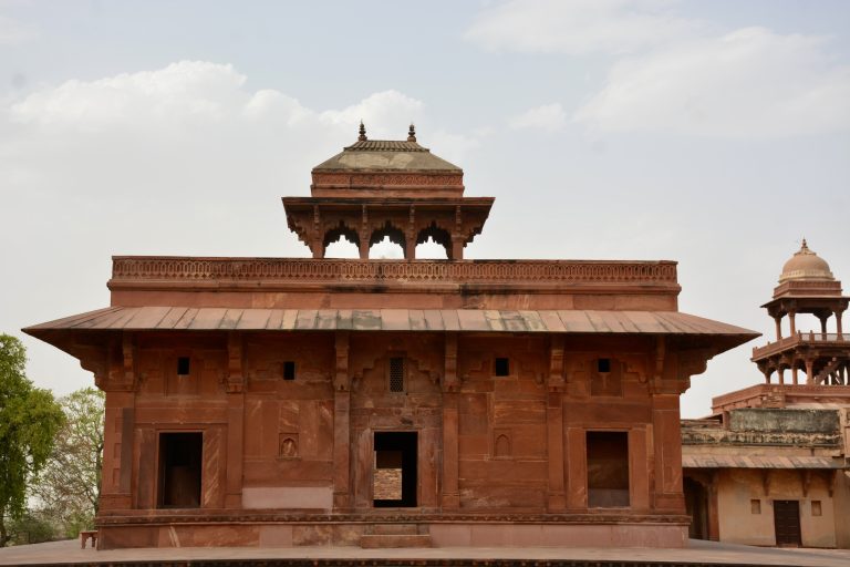 A symmetrical sandstone building with an elevated chhatri, part of the architectural grandeur of Fatehpur Sikri, Uttar Pradesh.