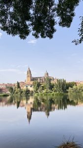 Salamanca Cathedral, on a hill, reflection seen in the water.