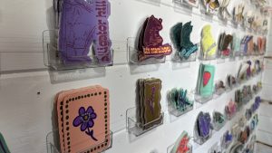 A wall with an array of stickers on display.