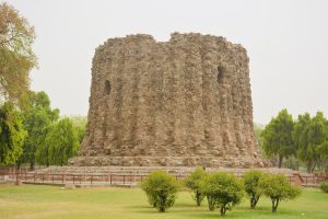 Front view of the Alai Minar near Qutab Minar, Delhi, surrounded by gardens and greenery, telling stories of an unfinished dream.
