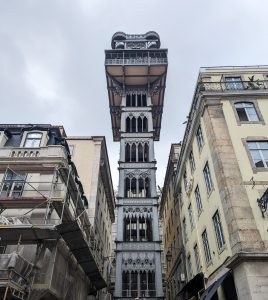 Low-angle view of the Santa Justa Elevator in Lisbon, Portugal framed between two tall buildings.